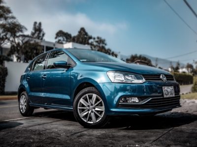 A blue Volkswagen is parked on the street, which RED Shield Administration can protect